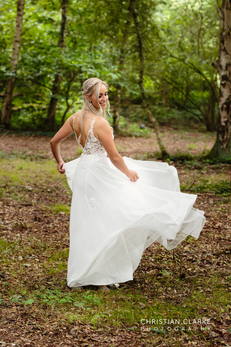 Eine Braut tanzt mit ihrem Brautkleid im Wald